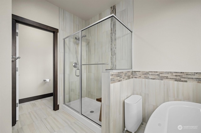 bathroom with a shower with shower door, tile walls, and toilet