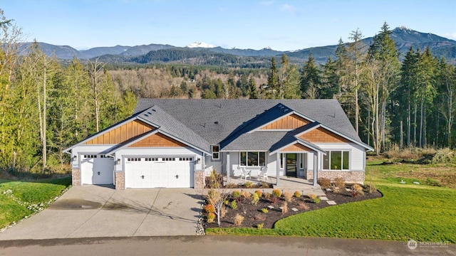 craftsman inspired home with a mountain view, a front yard, and a garage