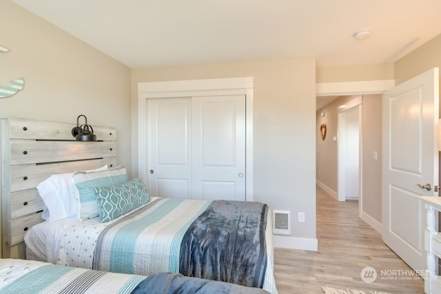 bedroom with light hardwood / wood-style floors and a closet