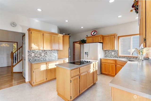 kitchen featuring a kitchen island, light countertops, recessed lighting, black electric cooktop, and a sink