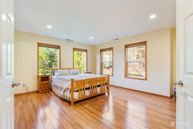 bedroom with visible vents, multiple windows, and light wood finished floors