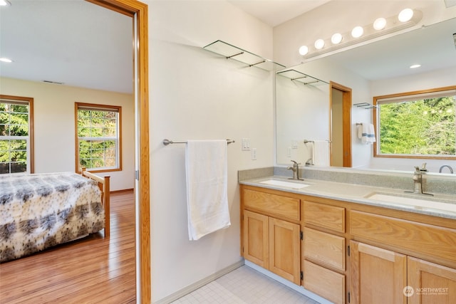 full bathroom with double vanity, baseboards, visible vents, and a sink