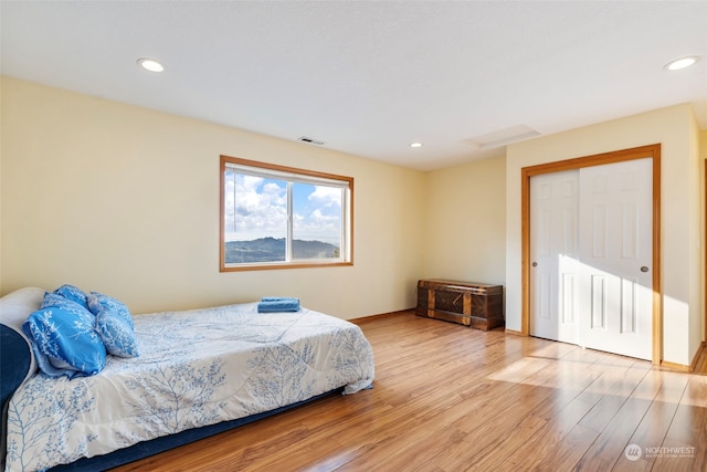 bedroom with recessed lighting, visible vents, baseboards, and wood finished floors