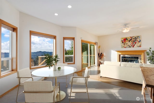 dining area featuring baseboards, a premium fireplace, recessed lighting, a mountain view, and a ceiling fan