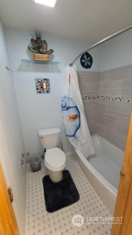 bathroom featuring tile patterned floors, toilet, and shower / bathtub combination with curtain