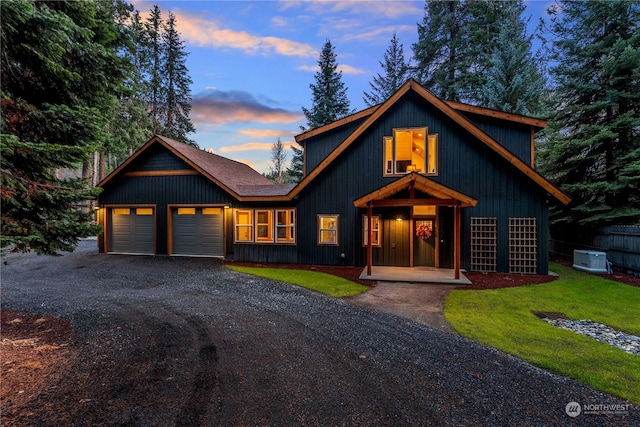 view of front of house featuring central AC, a yard, and a garage