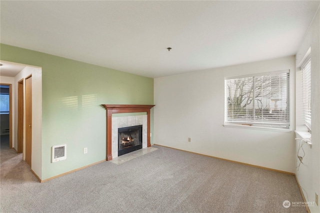 unfurnished living room with carpet and a tile fireplace