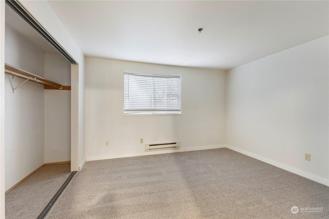 unfurnished bedroom with carpet, a baseboard heating unit, and a closet