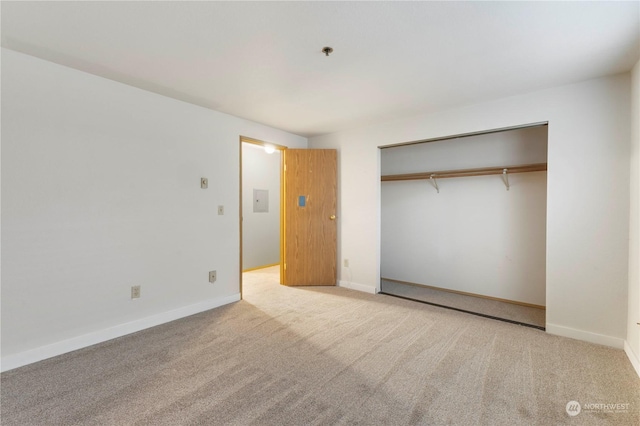 unfurnished bedroom featuring light colored carpet and a closet