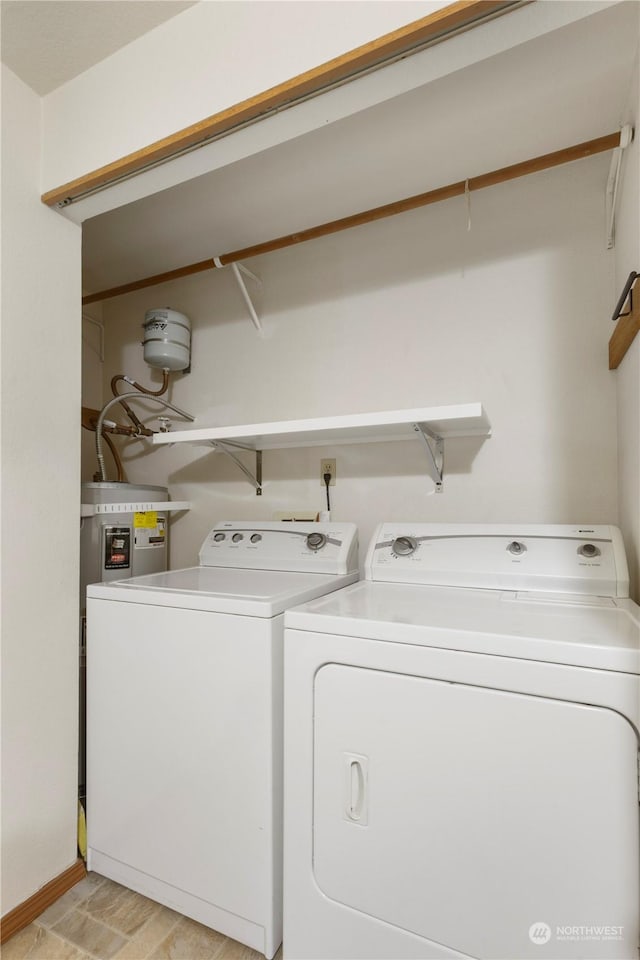 washroom with washing machine and dryer, water heater, and light wood-type flooring