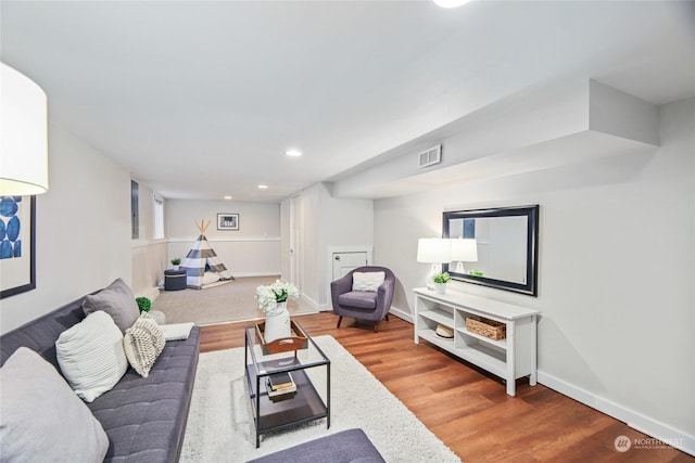 living area featuring visible vents, recessed lighting, baseboards, and wood finished floors