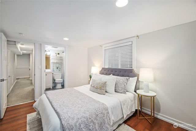 bedroom with baseboards, dark wood-style flooring, and ensuite bathroom