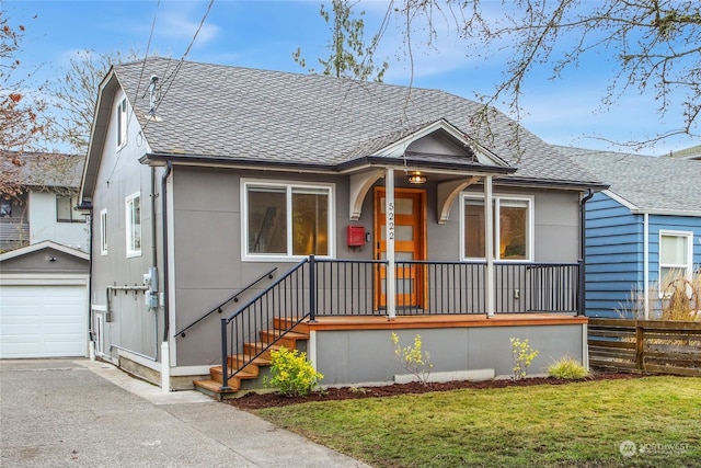 bungalow-style home with a garage, an outdoor structure, and a front lawn