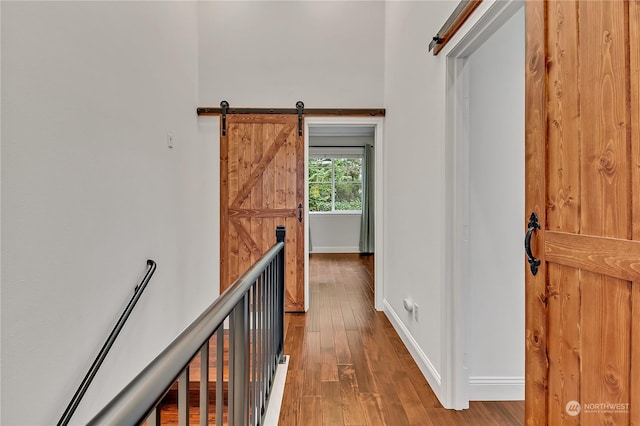 corridor featuring a barn door and hardwood / wood-style flooring