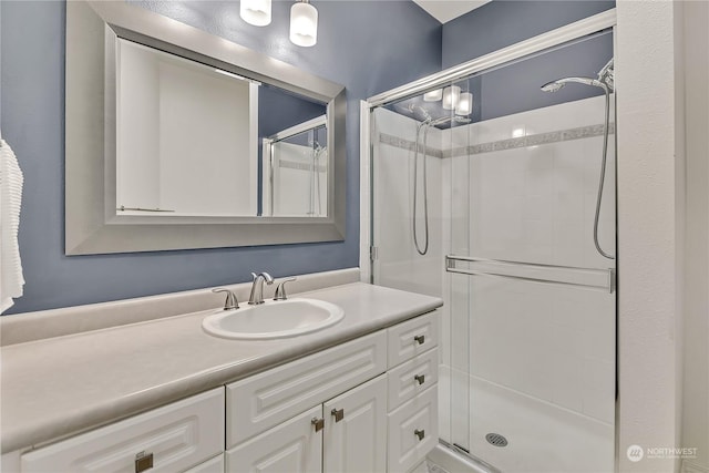 bathroom with a shower with door and vanity