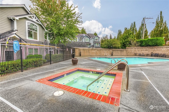 view of pool with an in ground hot tub