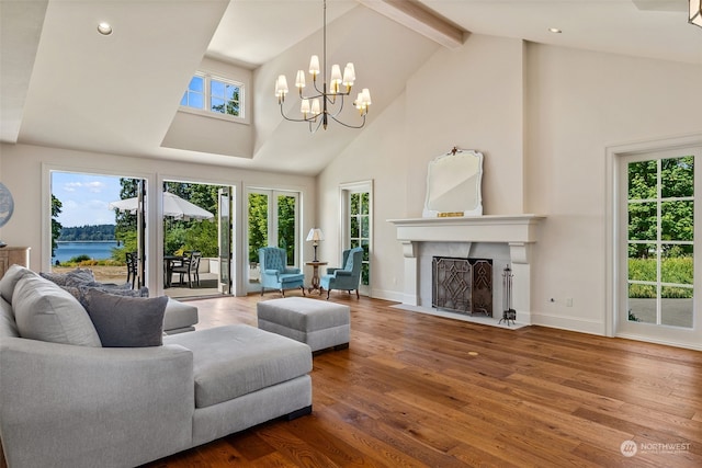 living room with a water view, wood-type flooring, high vaulted ceiling, a chandelier, and beam ceiling