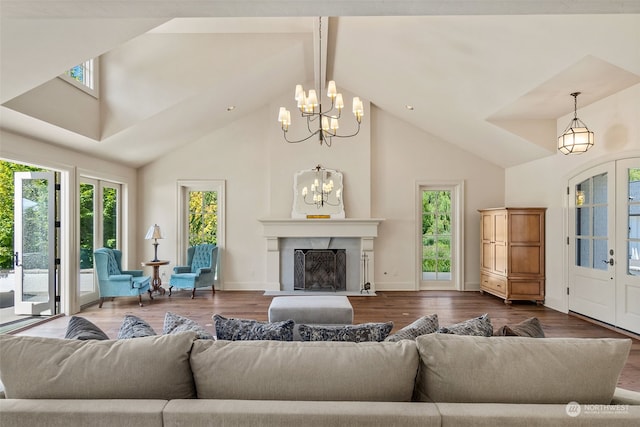 living room with hardwood / wood-style floors, an inviting chandelier, and beamed ceiling