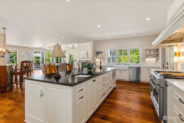 kitchen with a center island with sink, appliances with stainless steel finishes, premium range hood, sink, and white cabinetry