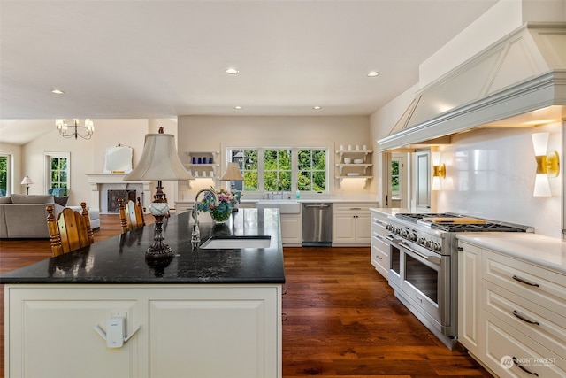 kitchen featuring stainless steel appliances, dark hardwood / wood-style floors, a kitchen island, sink, and white cabinetry