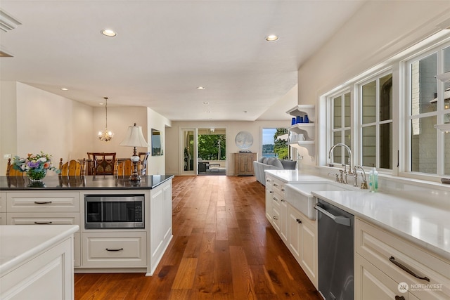 kitchen with stainless steel appliances, white cabinetry, dark hardwood / wood-style flooring, and sink