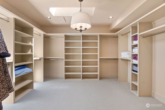 walk in closet with light colored carpet and a skylight