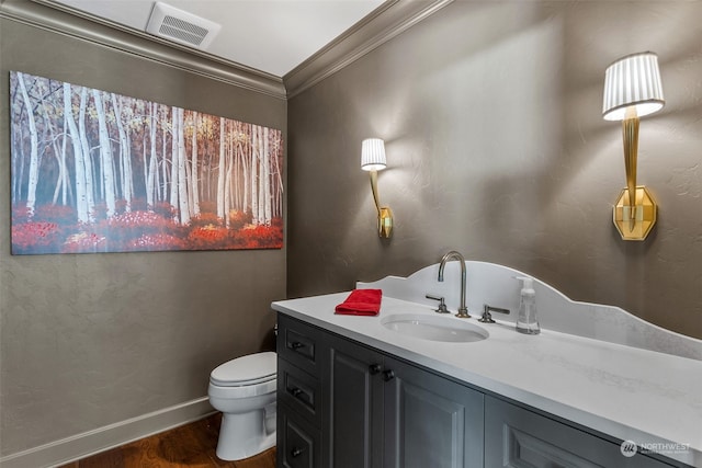 bathroom with toilet, hardwood / wood-style floors, vanity, and ornamental molding