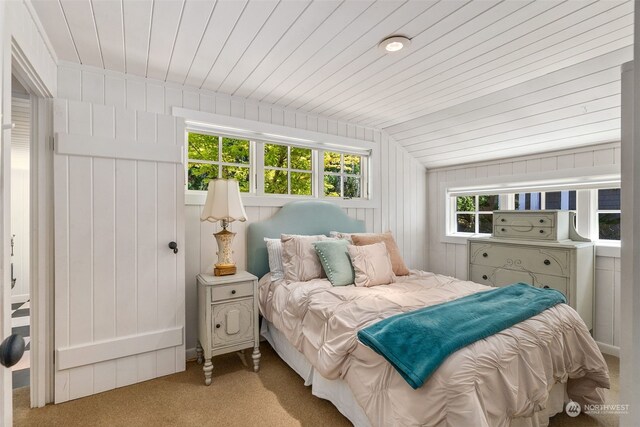 carpeted bedroom with vaulted ceiling and wood ceiling