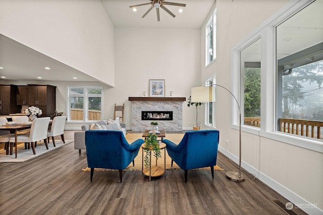 living room with ceiling fan, a fireplace, plenty of natural light, and dark hardwood / wood-style flooring