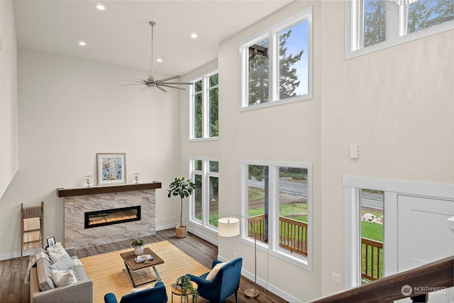 living room featuring a high ceiling, plenty of natural light, and a fireplace