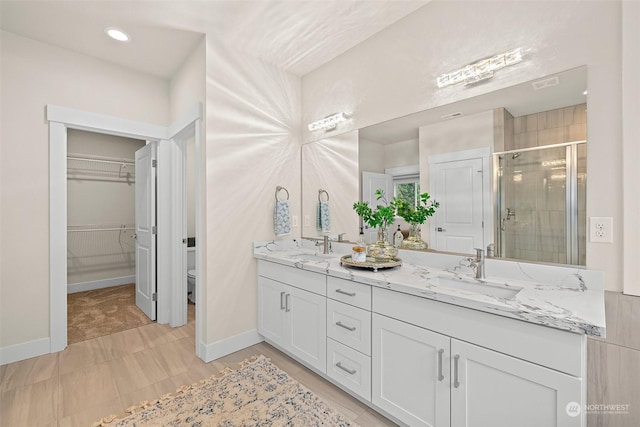 bathroom with walk in shower, vanity, and toilet