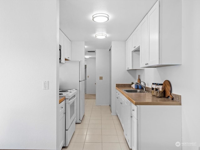 kitchen with white cabinets, sink, light tile patterned floors, and white appliances