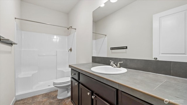 bathroom featuring a shower, vanity, and toilet