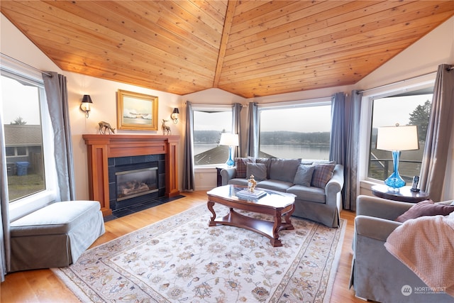 living room featuring a tiled fireplace, vaulted ceiling, wooden ceiling, and light wood-type flooring