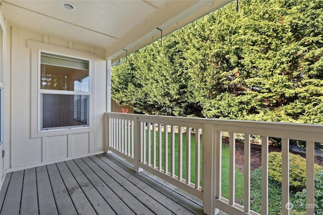 wooden deck featuring a lawn