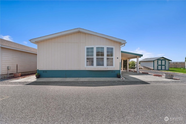 view of property exterior with a carport and a storage unit