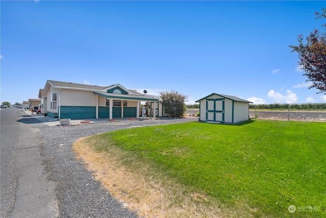 single story home with a storage unit and a front lawn