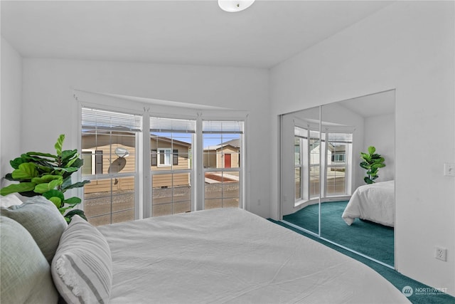 carpeted bedroom featuring lofted ceiling and access to outside