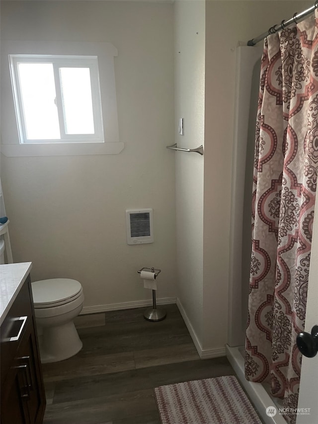 bathroom with hardwood / wood-style floors, vanity, a shower with shower curtain, toilet, and heating unit