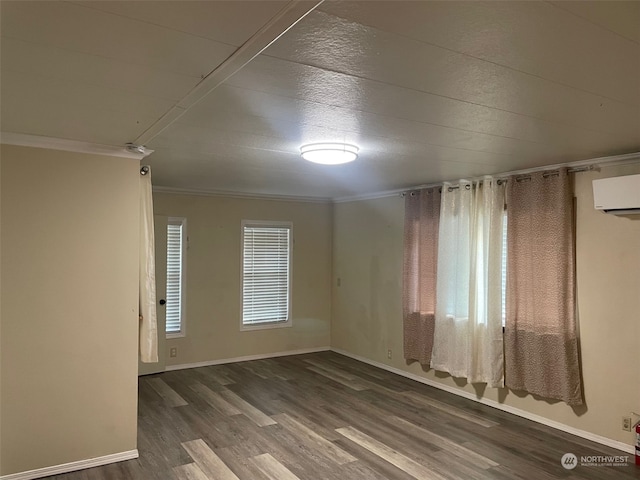 spare room featuring a wall mounted AC, hardwood / wood-style floors, and ornamental molding