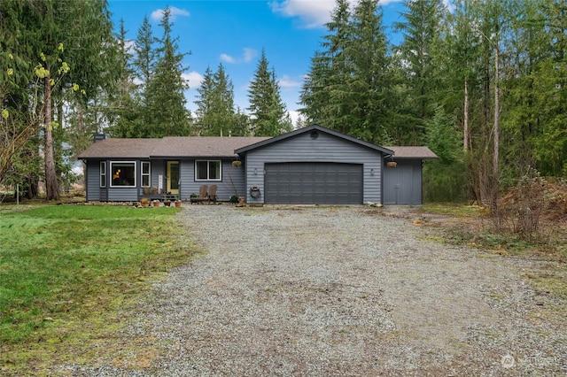 ranch-style house featuring a garage and a front lawn