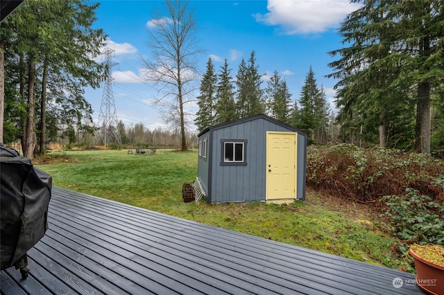 deck featuring a lawn, grilling area, and a storage shed