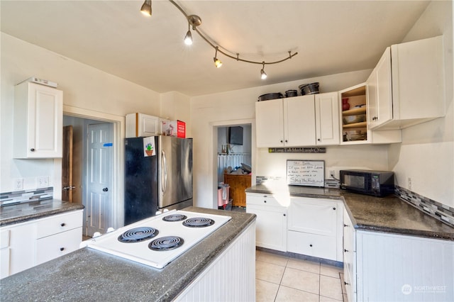 kitchen with light tile patterned flooring, white cabinetry, white electric stovetop, and stainless steel fridge