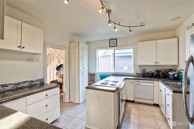 kitchen featuring white dishwasher, white cabinetry, light tile patterned floors, and a center island