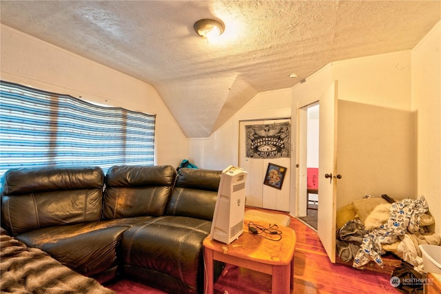 living room featuring wood-type flooring, lofted ceiling, and a textured ceiling