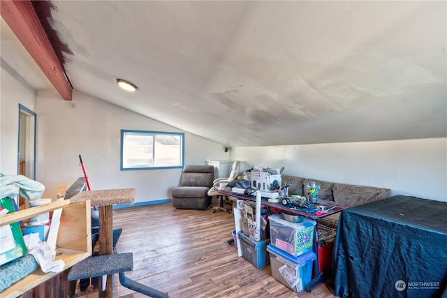 additional living space featuring hardwood / wood-style floors and vaulted ceiling with beams