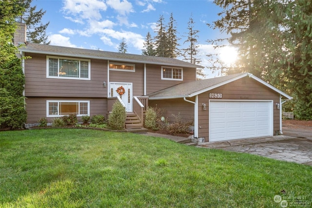 bi-level home with a garage and a front lawn