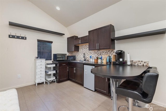 kitchen featuring dishwasher, dark brown cabinets, sink, and vaulted ceiling