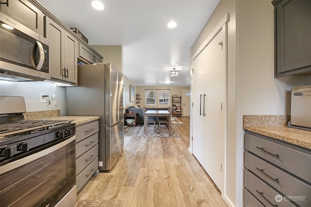 kitchen with stainless steel appliances, light wood-type flooring, and gray cabinets