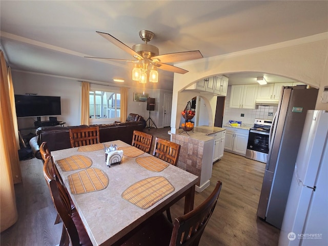 dining room featuring hardwood / wood-style flooring, ceiling fan, and crown molding